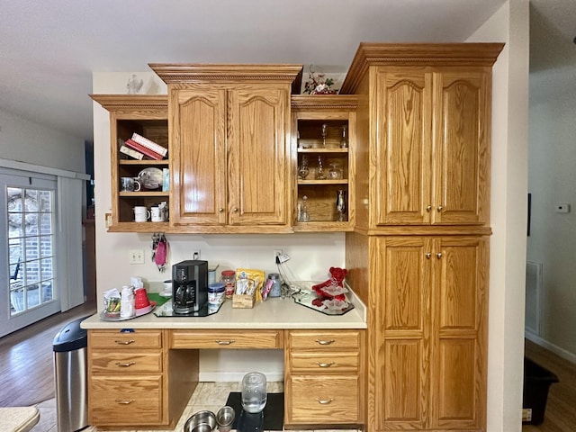 kitchen featuring built in desk, wood finished floors, light countertops, and open shelves