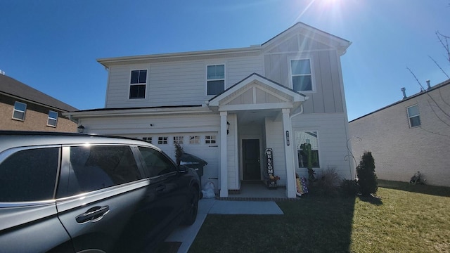 view of front of house with a garage, board and batten siding, and a front lawn