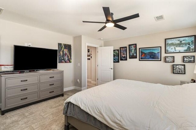 bedroom with a ceiling fan, baseboards, visible vents, and light carpet
