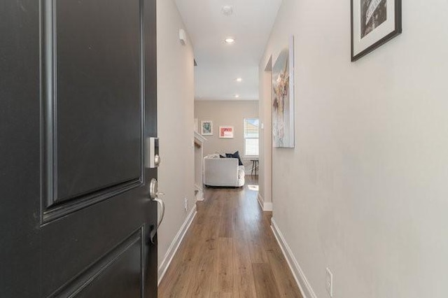 corridor with recessed lighting, baseboards, and wood finished floors