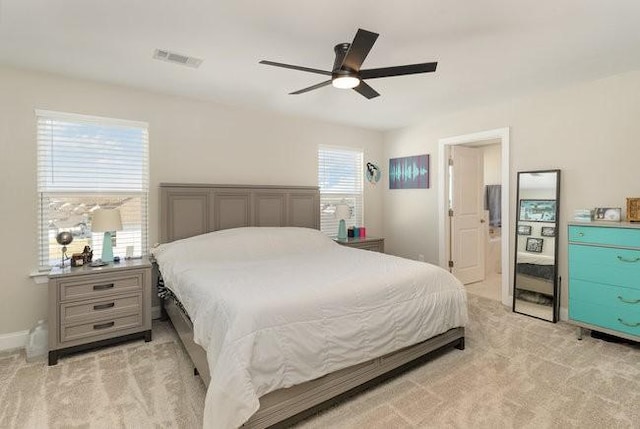 bedroom with visible vents, baseboards, light colored carpet, and ceiling fan