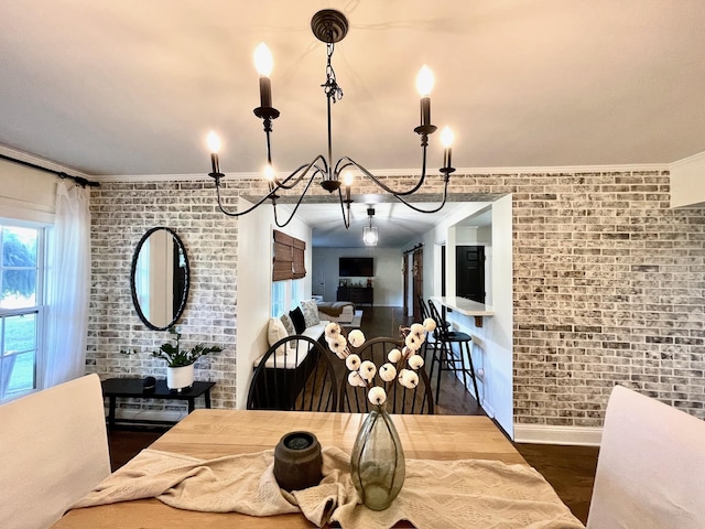 dining space featuring baseboards, wood finished floors, brick wall, and ornamental molding