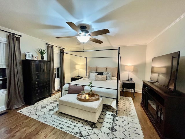 bedroom with wood finished floors, baseboards, and ornamental molding