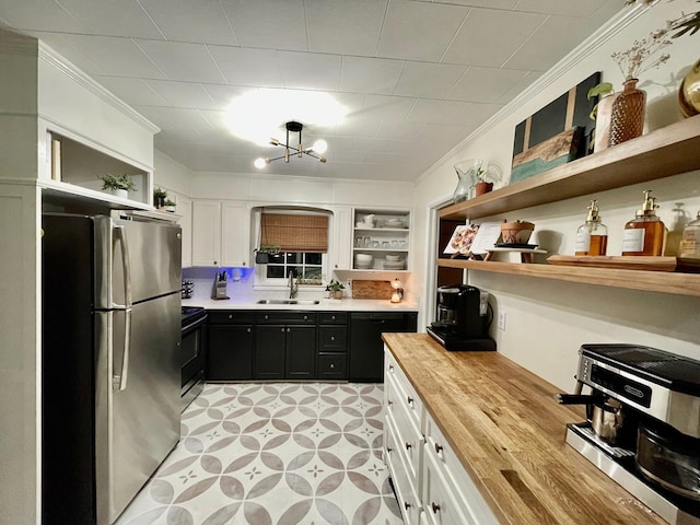 kitchen with open shelves, wood counters, a sink, and freestanding refrigerator