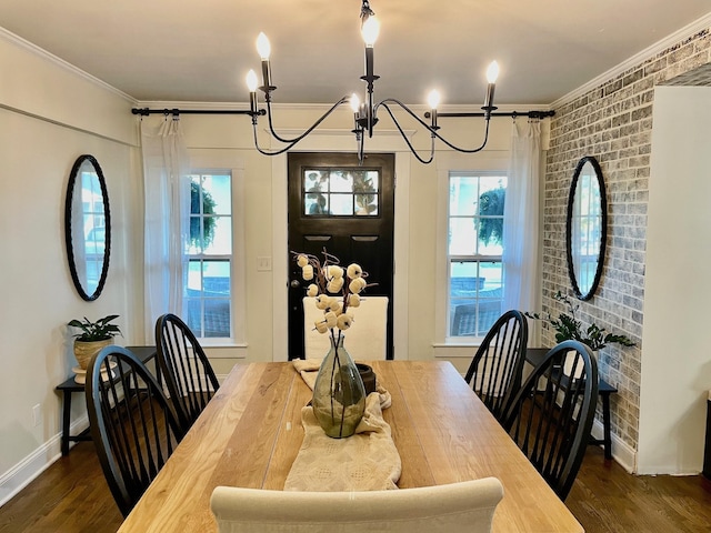 dining space with ornamental molding, dark wood finished floors, brick wall, baseboards, and a chandelier