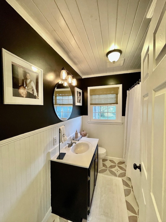 bathroom featuring vanity, toilet, wooden ceiling, and wainscoting