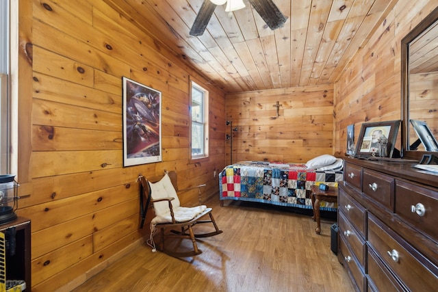 bedroom featuring wood ceiling, wood walls, and light wood finished floors