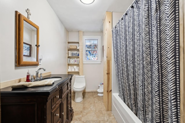 bathroom with toilet, vanity, and baseboards