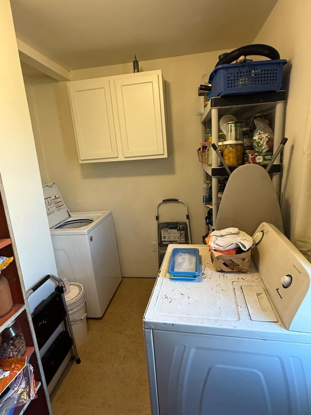 clothes washing area with cabinet space and independent washer and dryer