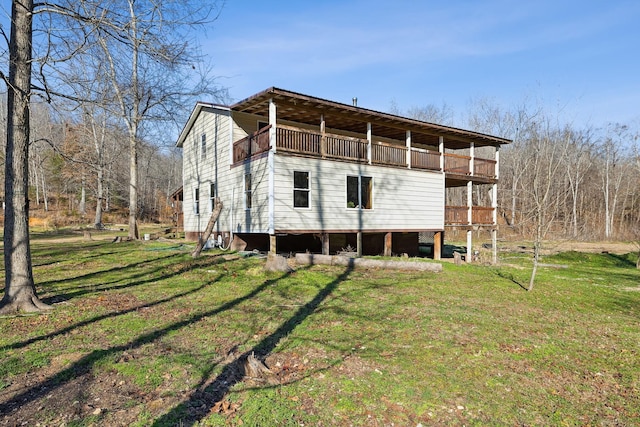 rear view of house featuring a balcony and a lawn