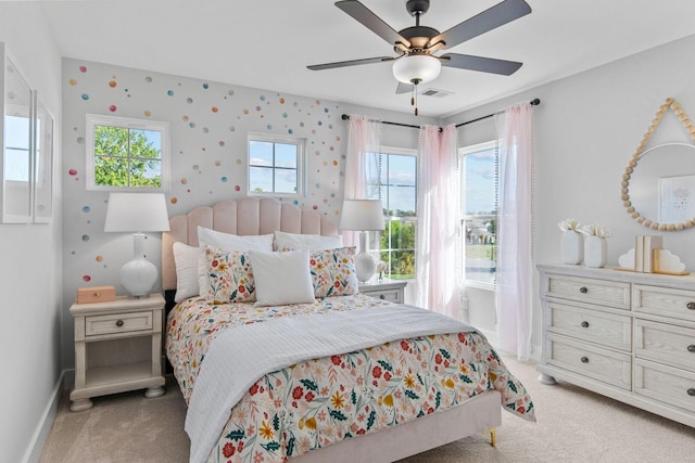 bedroom with visible vents, wallpapered walls, baseboards, light carpet, and a ceiling fan