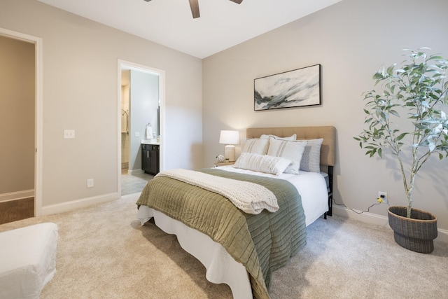 bedroom featuring light carpet, ensuite bathroom, and baseboards