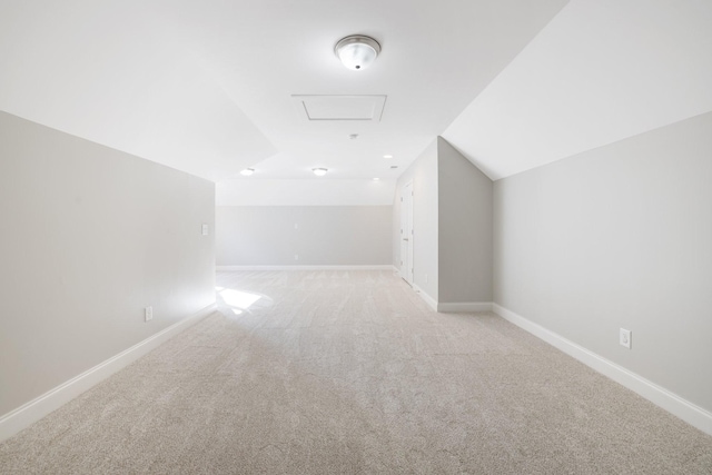 bonus room with baseboards, lofted ceiling, attic access, and light carpet