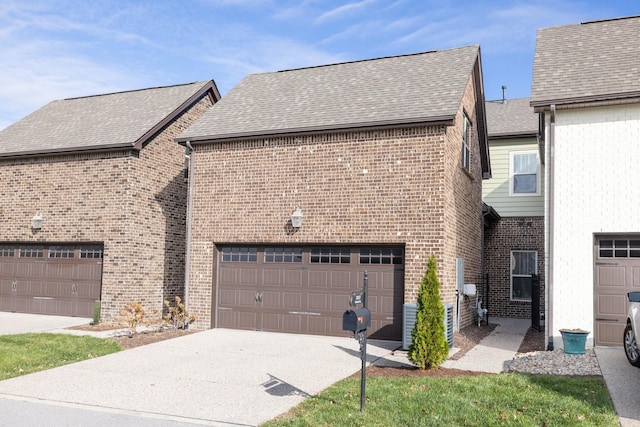 view of home's exterior featuring driveway, a garage, brick siding, and roof with shingles