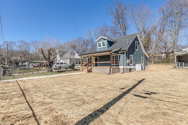 view of property exterior featuring a porch, fence, and roof with shingles