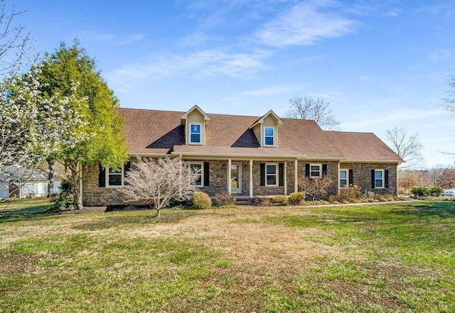 cape cod home with brick siding, roof with shingles, and a front lawn