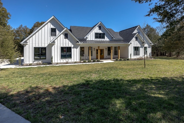 modern farmhouse style home with metal roof, board and batten siding, a front yard, and a standing seam roof