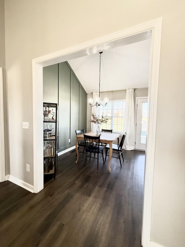 dining space with baseboards, a notable chandelier, and dark wood finished floors