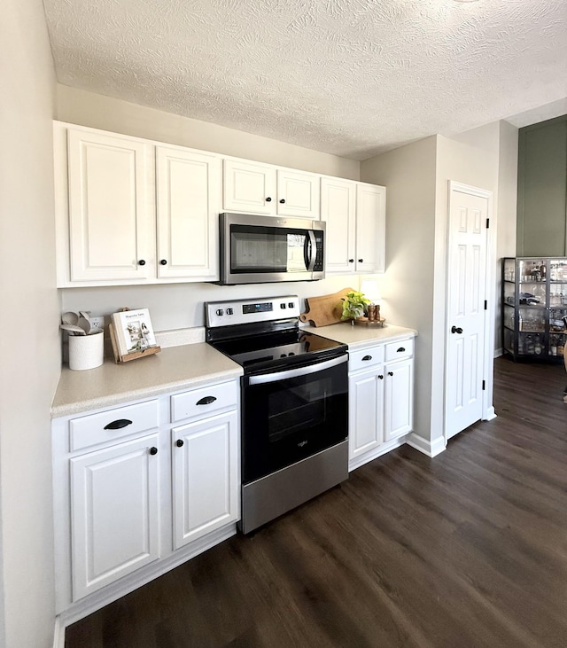 kitchen featuring dark wood-type flooring, white cabinets, light countertops, appliances with stainless steel finishes, and a textured ceiling