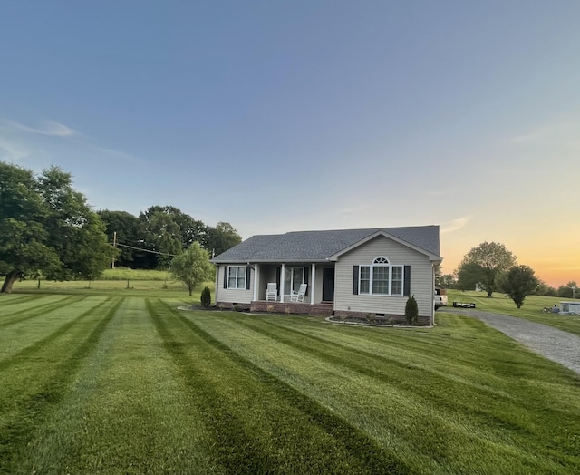 view of front of property featuring crawl space, driveway, a shingled roof, and a front yard