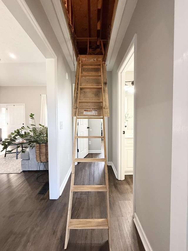 hallway featuring baseboards and dark wood finished floors