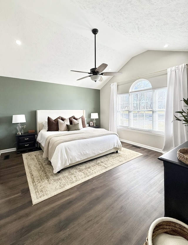 bedroom featuring visible vents, baseboards, vaulted ceiling, dark wood-style floors, and a textured ceiling