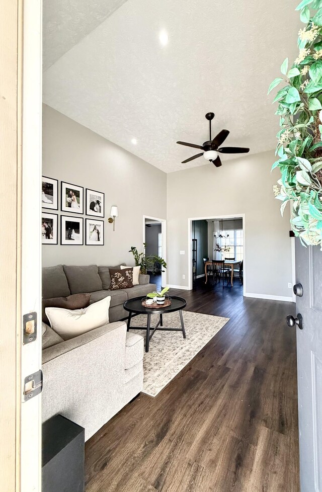 living area featuring dark wood finished floors, ceiling fan, a textured ceiling, and baseboards