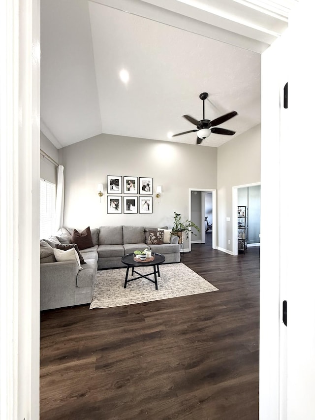 living area featuring dark wood finished floors, ceiling fan, baseboards, and lofted ceiling