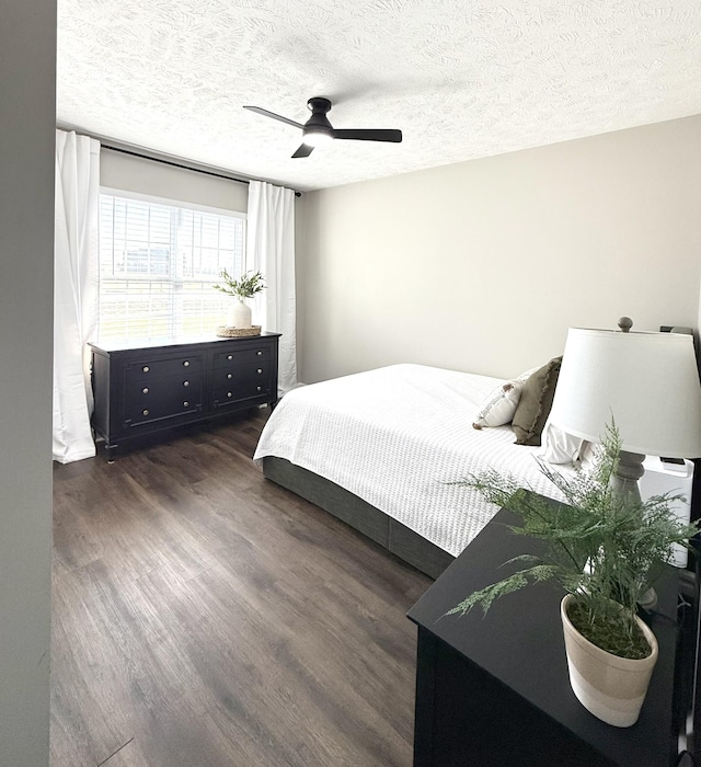 bedroom with dark wood finished floors, a ceiling fan, and a textured ceiling