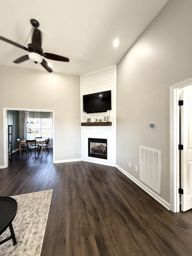 unfurnished living room with a fireplace, wood finished floors, visible vents, and baseboards