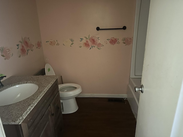 bathroom featuring vanity, wood finished floors, visible vents, baseboards, and toilet