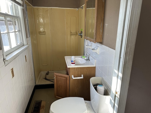 full bathroom featuring walk in shower, visible vents, toilet, and tile walls