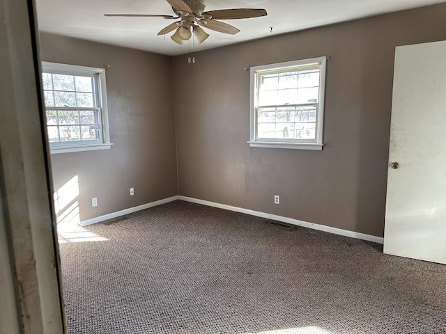 unfurnished room featuring visible vents, carpet floors, baseboards, and a ceiling fan