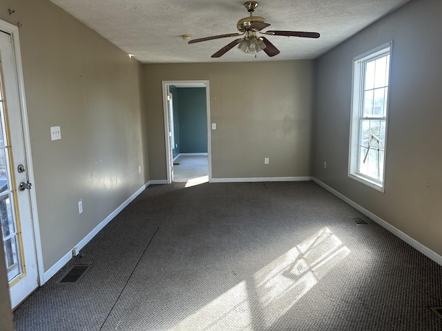 carpeted spare room with visible vents, baseboards, a textured ceiling, and ceiling fan