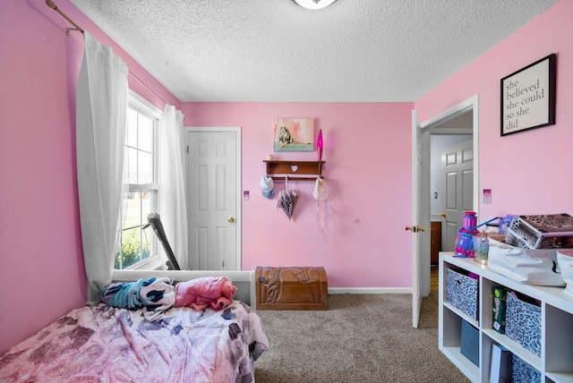 bedroom with baseboards, carpet floors, and a textured ceiling