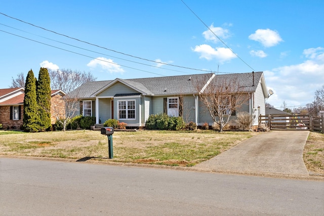 single story home with roof with shingles, a front lawn, and fence