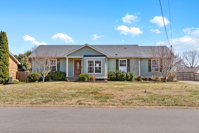 single story home with roof with shingles, a front lawn, and fence