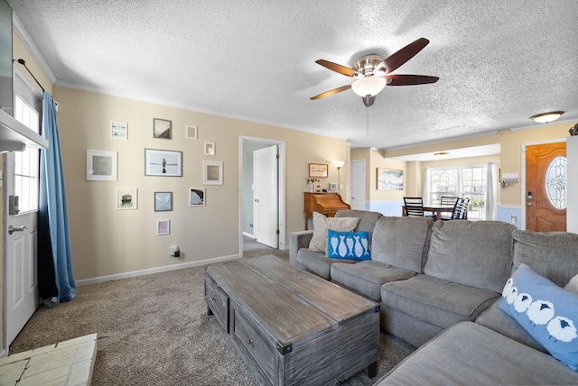 carpeted living area with baseboards, a textured ceiling, and a ceiling fan