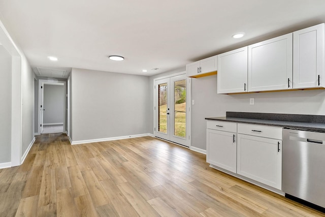 kitchen with dark countertops, baseboards, dishwasher, light wood-style flooring, and white cabinetry