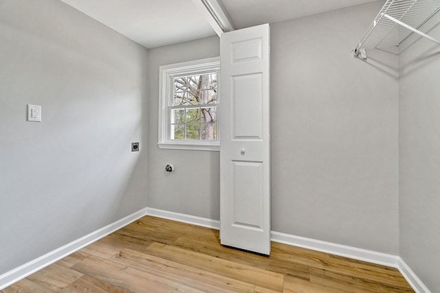 clothes washing area featuring light wood-style floors, baseboards, and electric dryer hookup