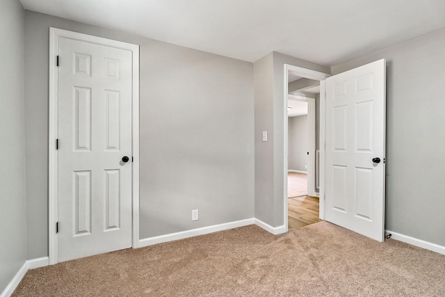 unfurnished bedroom with carpet flooring and baseboards