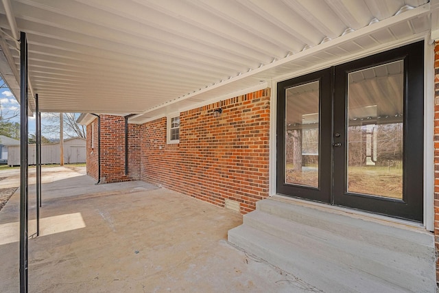 view of patio / terrace with french doors, a storage shed, and an outdoor structure