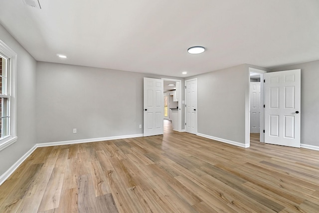 spare room featuring light wood-type flooring and baseboards