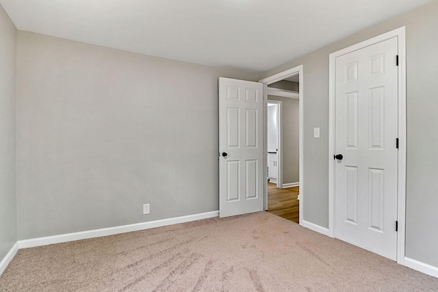 unfurnished bedroom featuring carpet flooring and baseboards