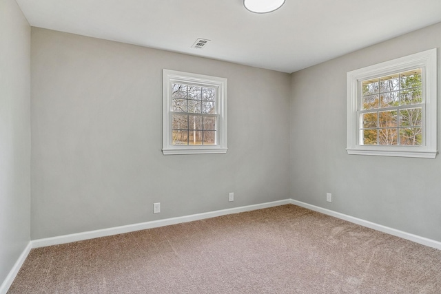 empty room with visible vents, baseboards, and carpet