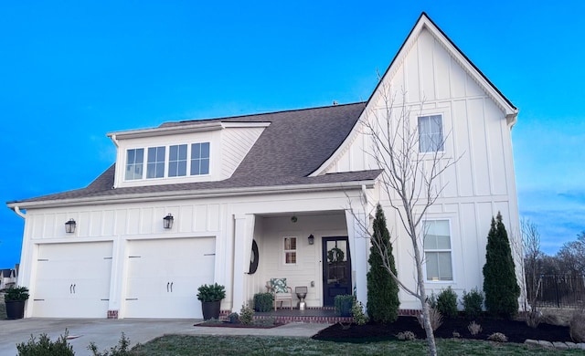 modern farmhouse style home with covered porch, board and batten siding, a shingled roof, and a garage