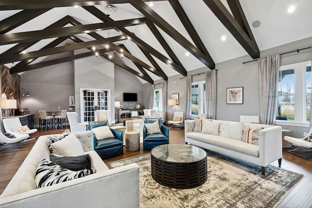 living room featuring visible vents, beam ceiling, high vaulted ceiling, and wood finished floors