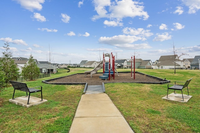 communal playground featuring a residential view and a lawn