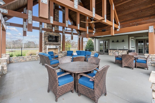 view of patio featuring an outdoor living space with a fireplace, outdoor dining area, french doors, and fence