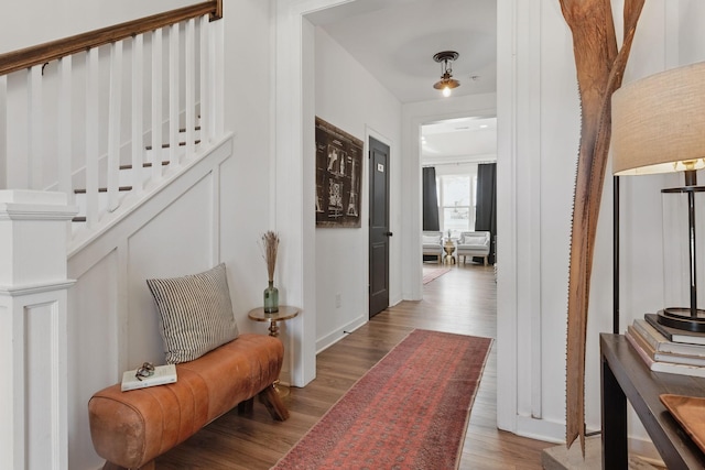 corridor featuring wood finished floors and stairway